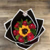 Red roses and a yellow sunflower in a black-and-white wrap