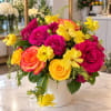 Bright pink and yellow rose bouquet in a white vase