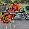 Orange floral tribute on an easel with a Harley-Davidson sign