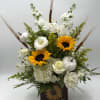 White floral arrangement with sunflowers in a dark vase and white pumpkins