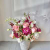 Pink and white floral arrangement in a textured white vase
