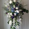 Tall white and purple floral spray on a black stand