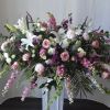 Large floral spray with pink and white flowers on a pedestal