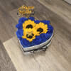 Small box with red roses and sunflowers, a gold metal butterfly, ribbon