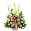 Pink and yellow mixed flower arrangement in a white container