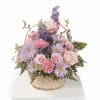 Basket arrangement of pink and lavender flowers with roses and daisies