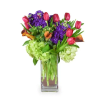 Bouquet of pink tulips and purple flowers in a glass vase