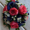 Bouquet of pink roses with white filler flowers and dark blue ribbon