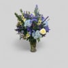 Mixed blue and purple flower arrangement in a glass vase