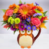 Colorful flower arrangement in an owl-shaped ceramic mug