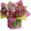 Bright pink and green mixed flower arrangement in a pink gift box with a green polka-dot bow