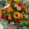 Assorted mixed fall flowers in a ceramic vase