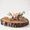 Small pastel floral arrangement on a wood slice