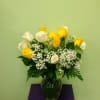 Yellow and white roses in a glass vase with baby's breath