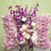 Pink and purple floral standing arrangement with white roses on an easel