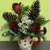 Red roses and pinecones arranged in a snowman mug