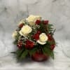 White roses and red carnations arranged in a red ornament-shaped vase