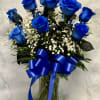 Blue roses in a glass vase with white baby's breath and a blue ribbon