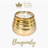 Gold candle in a rounded metallic holder with a white wick