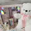 Gift basket with a teddy bear, boxed tumbler set, and pens