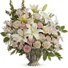 Bouquet of white lilies, cream roses, and pink carnations in a pedestal vase