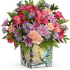 Mixed pink and purple bouquet in a decorative square vase