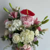 Mixed pink and white flowers in a round birthday box with a red anthurium