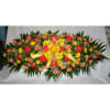Oval floral spray with red roses, yellow daisies, and a gold ribbon bow