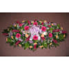 Large floral casket spray with pink gerbera daisies and a lavender ribbon
