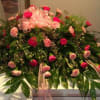 Large pink and red floral spray with ribbon accents