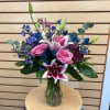 Pink and white lilies with pink roses in a glass vase