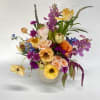 Colorful mixed bouquet in a white vase with orchids and roses