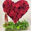 Heart-shaped red rose arrangement on a moss-covered base