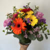Seasonal mix of gerbera daisies and daisies arranged with filler and greens