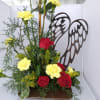 Red roses and yellow carnations arranged with angel wings