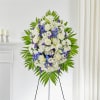 Standing floral spray with white and purple flowers on an easel