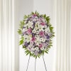 Standing floral wreath with white lilies, pink roses, and purple daisies