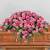 Pink roses and carnations arranged on a wooden casket