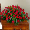 Red carnation arrangement on a wooden casket