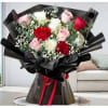Bouquet of red, pink, and white roses wrapped in black paper