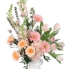 Pink and peach floral arrangement in a white pedestal vase