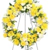 Yellow and white floral wreath on a metal stand
