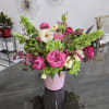 Pink and white floral arrangement in a pink vase
