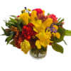 Mixed bouquet of yellow, red, and purple flowers in a glass vase