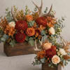 Orange and cream floral arrangements with antlers in wooden boxes