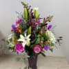 A showstopper overflowing with snapdragons, lavender roses, white Casablanca lilies, hydrangea and