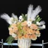 Peach roses and white flowers in a white-and-gold vase