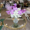 Purple and white orchid arrangement in a glass vase