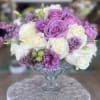 Lavender and white roses arranged in a clear glass vase