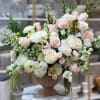 Large pastel rose arrangement in a brown urn vase